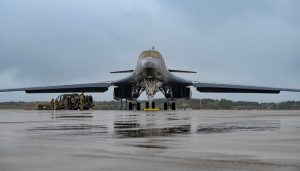 While the B-1B Lancer soars overhead, an extensive crew of Airmen watches proudly from the ground, admiring the results of their hard work and determination.